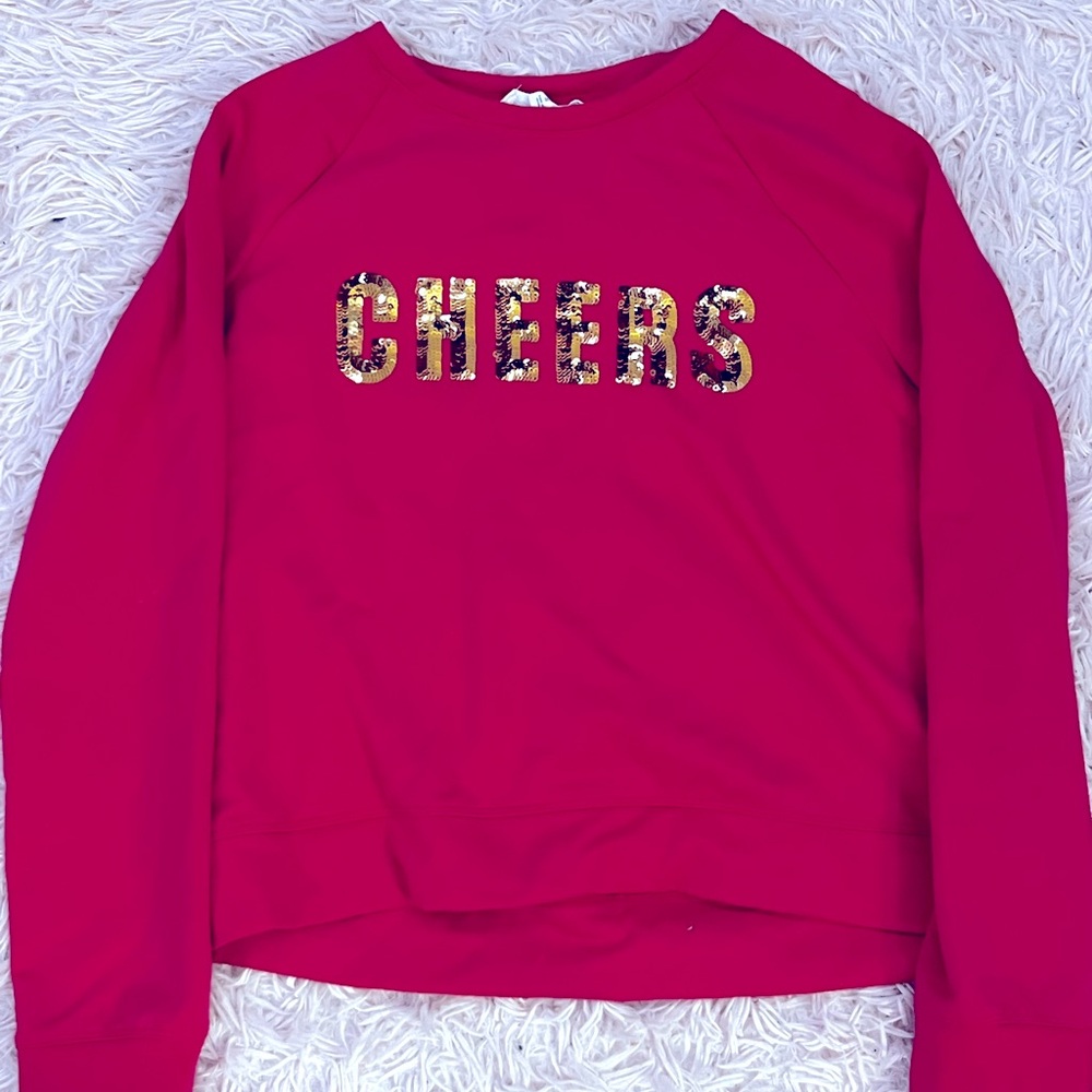 Hot pink sweatshirt with a gold print “Cheers”